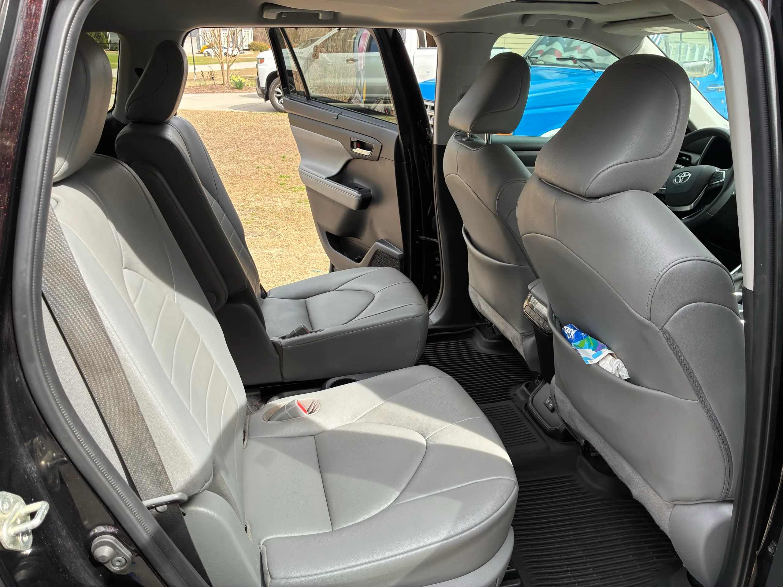 Second-row seats of a Toyota Highlander with clean gray leather and vacuumed floor